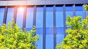 City life, urban landscape and ecology. Modern office complex with glass facades and smooth lines against backdrop of green trees, concept of modern architecture. Organically building into nature. photo