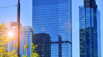 City life, urban landscape and ecology. Modern office complex with glass facades and smooth lines against backdrop of green trees, concept of modern architecture. Organically building into nature. photo