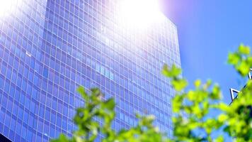 City life, urban landscape and ecology. Modern office complex with glass facades and smooth lines against backdrop of green trees, concept of modern architecture. Organically building into nature. photo