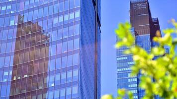 City life, urban landscape and ecology. Modern office complex with glass facades and smooth lines against backdrop of green trees, concept of modern architecture. Organically building into nature. photo