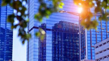 City life, urban landscape and ecology. Modern office complex with glass facades and smooth lines against backdrop of green trees, concept of modern architecture. Organically building into nature. photo