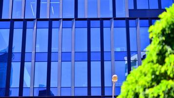 City life, urban landscape and ecology. Modern office complex with glass facades and smooth lines against backdrop of green trees, concept of modern architecture. Organically building into nature. photo