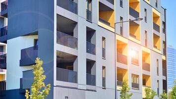 New modern block of flats in green area. Eco apartment building saving energy and fresh air concept. Green tree and new apartment building. The harmony of nature and modernity. photo