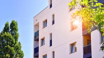 New modern block of flats in green area. Eco apartment building saving energy and fresh air concept. Green tree and new apartment building. The harmony of nature and modernity. photo