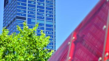 City life, urban landscape and ecology. Modern office complex with glass facades and smooth lines against backdrop of green trees, concept of modern architecture. Organically building into nature. photo