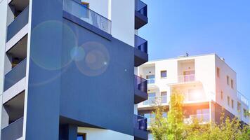 New modern block of flats in green area. Eco apartment building saving energy and fresh air concept. Green tree and new apartment building. The harmony of nature and modernity. photo