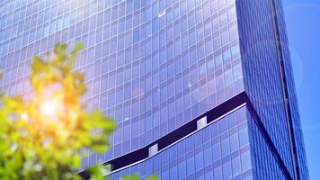 City life, urban landscape and ecology. Modern office complex with glass facades and smooth lines against backdrop of green trees, concept of modern architecture. Organically building into nature. photo