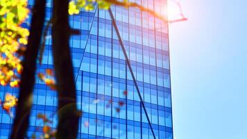 City life, urban landscape and ecology. Modern office complex with glass facades and smooth lines against backdrop of green trees, concept of modern architecture. Organically building into nature. photo