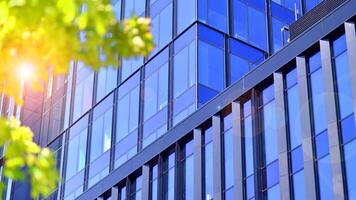 City life, urban landscape and ecology. Modern office complex with glass facades and smooth lines against backdrop of green trees, concept of modern architecture. Organically building into nature. photo