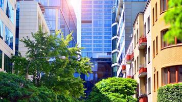 City life, urban landscape and ecology. Modern office complex with glass facades and smooth lines against backdrop of green trees, concept of modern architecture. Organically building into nature. photo
