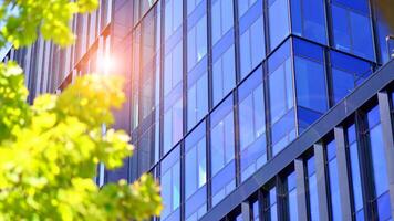 City life, urban landscape and ecology. Modern office complex with glass facades and smooth lines against backdrop of green trees, concept of modern architecture. Organically building into nature. photo