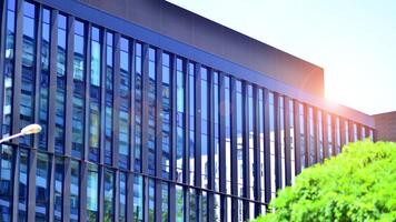 City life, urban landscape and ecology. Modern office complex with glass facades and smooth lines against backdrop of green trees, concept of modern architecture. Organically building into nature. photo