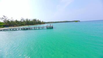 Dynamic FPV Shot Of Woman Practicing Yoga In Warrior Pose by the turquoise sea video