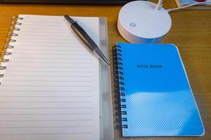 Office table with blank notebook, pen and laptop. office desk top view with blank notebook photo