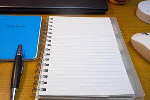 Office table with blank notebook, pen and laptop. office desk top view with blank notebook photo