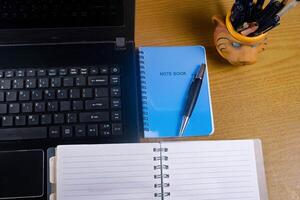 Office table with blank notebook, pen and laptop. office desk top view with blank notebook photo