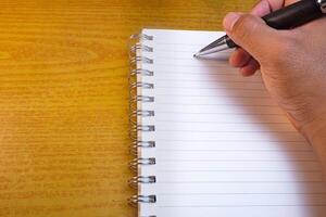 Hands holding pencils and notebooks. Hand with a pen is writing in a notebook. Mock-up Concept. photo