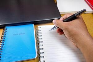 Hand with a pencil is writing in a notebook. hands holding pencils and notebooks. Mock-up Concept. photo
