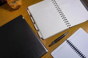 Office table with blank notebook, pen and laptop. office desk top view with blank notebook photo