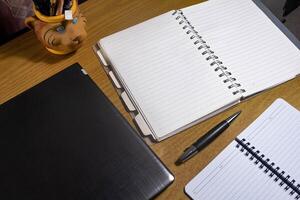 Office table with blank notebook, pen and laptop. office desk top view with blank notebook photo