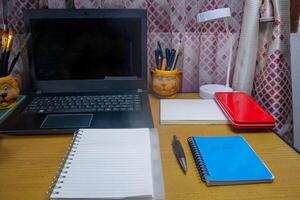 Office table with blank notebook, pen and laptop. office desk top view with blank notebook photo