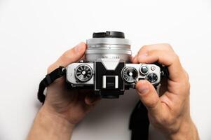 Photographer with camera on white background, close-up of hands and professional photo camera