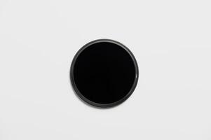 Dark ND filter on a white background. Flat image neutral density filter photo
