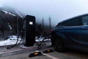 Using a charging station. Renewable energy concept. Electric car using sustainable source. Saving, climate change photo