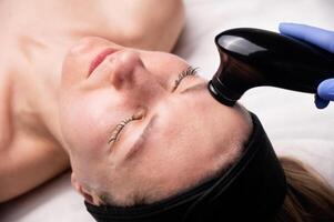 Face lifting. Hardware rejuvenating procedure, vacuum cleaning. Cosmetic procedure for the face, close-up photo