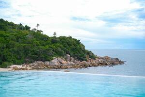 Beautiful view from infinity pool at luxury hotel against ocean front, tropical resort. Relaxing, summer, travel, holiday, vacation and weekend concept. photo