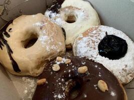 a box of donuts with powdered sugar and chocolate. photo