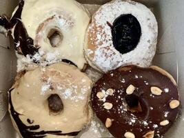 a box of donuts with powdered sugar and chocolate. photo