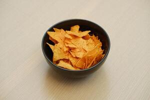 Nachos chips in a bowl on a wooden table photo