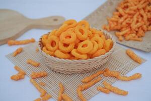 snack cheese crackers in a basket on bamboo mat with white background. photo