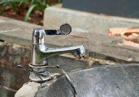 Metal stainless park water faucet object with two worker bees resting on it isolated on horizontal outdoor environment background. photo