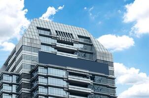 Mock up blue banner LED display billboard on tower building with blue sky background .clipping path for mockup photo