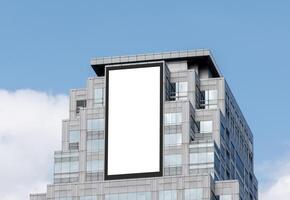Mock up white vertical large LED display billboard on tower building with blue sky background .clipping path for mockup photo