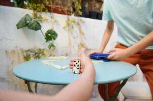 Playing a game of dominoes on a patio with friends, capturing a moment of fun and relaxation, amid lush greenery and a serene atmosphere. photo