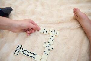 Child and adult play domino game on soft plush blanket creating a cozy and relaxing atmosphere for family bonding photo