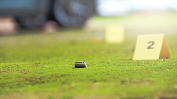 Spent bullet casing lying on the ground with blur number 2 sign. Concepts of shooting sports and security highlighting the dual nature of firearms in both competitive sport and protective measures. photo