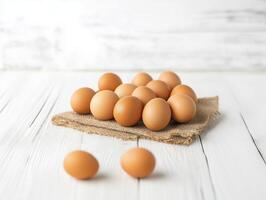 The concept of Easter day, world Egg Day, eco-farm and health nutrition. pile of fresh eggs on burlap fabric over a white wooden table background with copy space photo