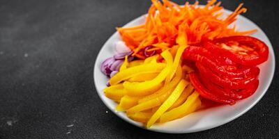 salad fresh vegetables cut into a plate tomato, carrot, pepper, onion juicy fresh gourmet food background on the table rustic food top view copy space keto and paleo diet Vegetarian and vegan photo