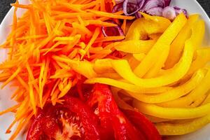 salad fresh vegetables cut into a plate tomato, carrot, pepper, onion juicy fresh gourmet food background on the table rustic food top view copy space keto and paleo diet Vegetarian and vegan photo