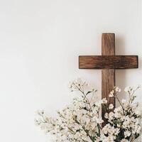 Rustic wooden cross with white flowers against a minimalist white background photo