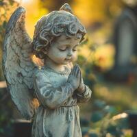Praying angel statue with a warm, golden light in a tranquil setting photo