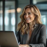 Professional businesswoman smiling while working on laptop in modern office setting photo