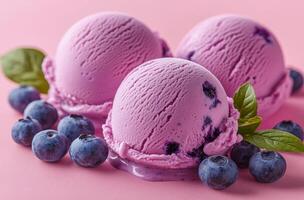 Three purple ice cream balls with blueberries on top. The blueberries are fresh and juicy, and the ice cream is creamy and smooth. The combination of flavors and textures creates a delicious photo