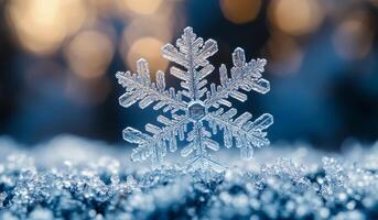A snowflake is sitting on top of a patch of snow. The snowflake is surrounded by a blue sky and the snow is white. Concept of calm and serenity photo