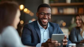 A smiling man in a suit is using a tablet photo
