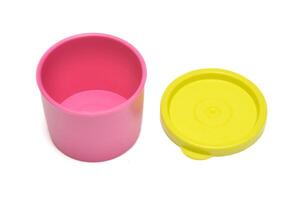 Pink tube plastic container with yellow lid white background photo